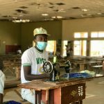 A young man sewing during the National Youth Service Corps program in Nigeria, promoting skill development.